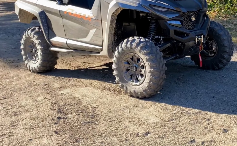 A Yamaha UTV is parked on a dirt surface.