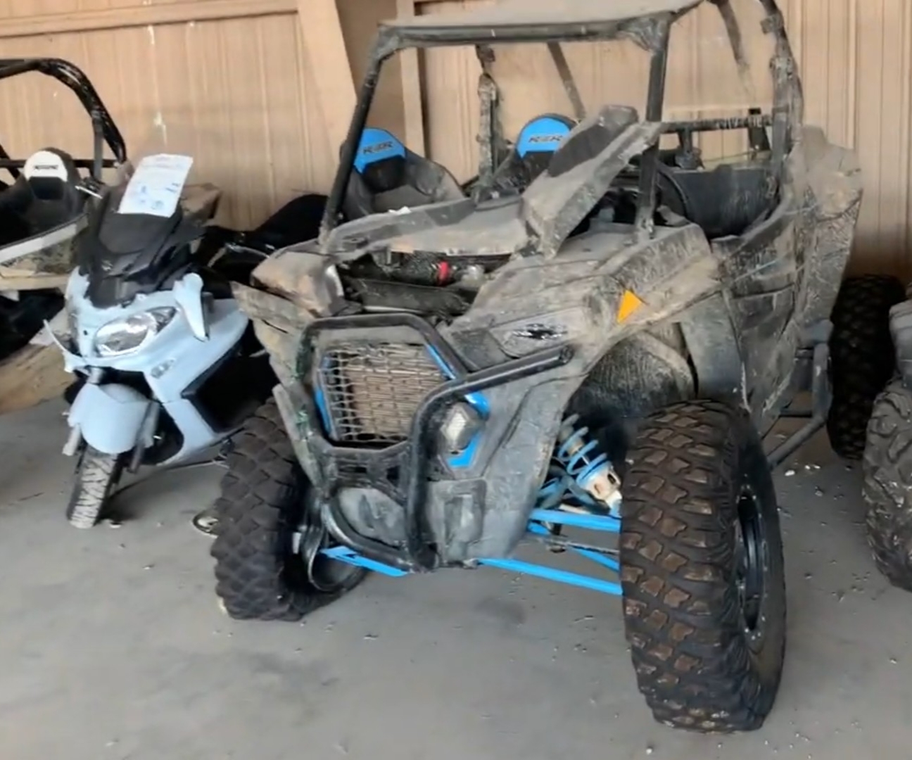 A broken Polaris UTV is parked in a UTV salvage yard.