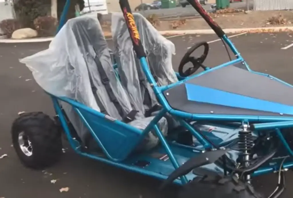 A blue child UTV is parked on a concrete road.