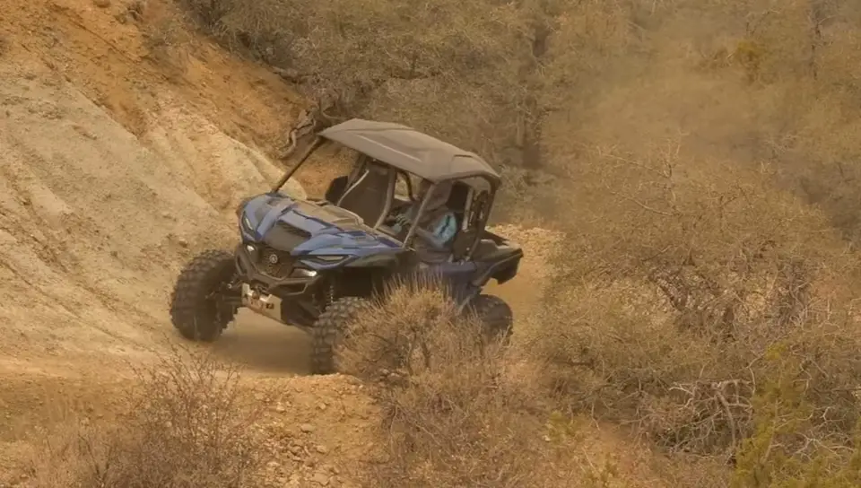 A Yamaha RMAX2 is being driven through a hill road.